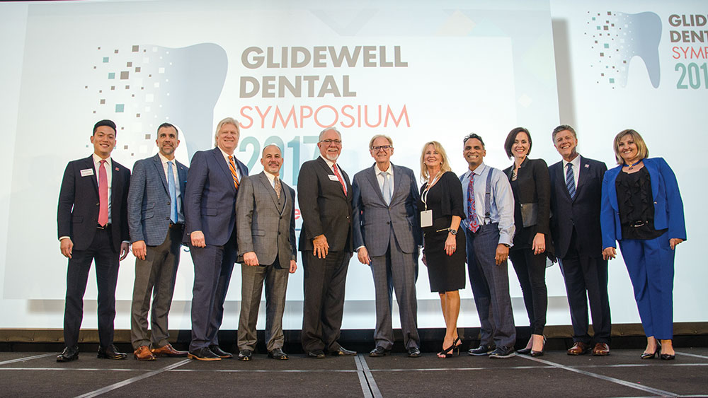 Speakers at the Glidewell Dental Symposium 2017 gathered on stage, (from left) Dr. Justin Chi, Dr. Chad Duplantis, Dr. Timothy Kosinski, Dr. Charles Schlesinger, Glidewell Dental President and CEO Jim Glidewell, Dr. Jack Hahn, Dr. Suzanne Haley, Dr. Paresh Patel, Carrie Webber, Dr. Neil Park and Dr. Anamaria Muresan