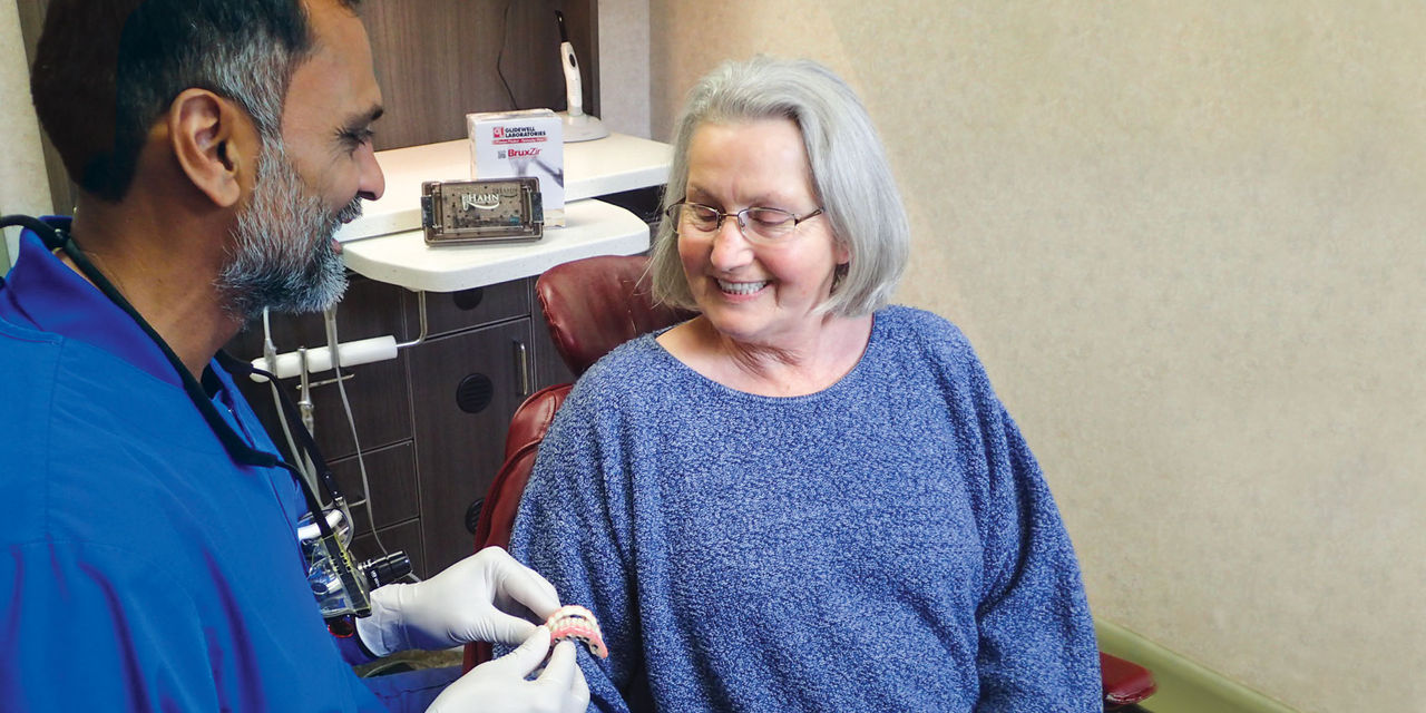 A dentist helps an edentulous patient
