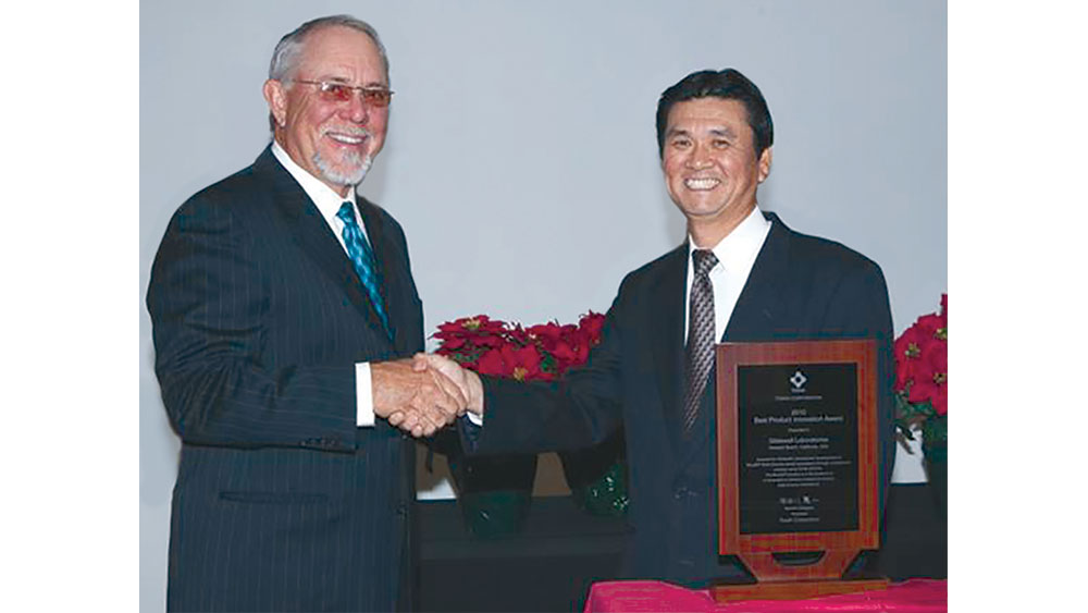 Jim Glidewell accepts an award from Yutaka Nakamura from Tosoh America