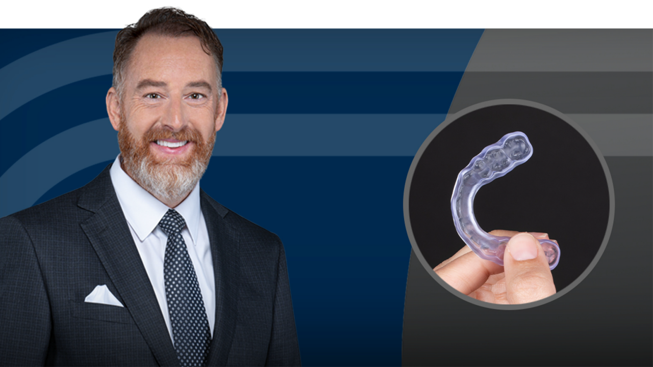 Clear dental aligner held in hand