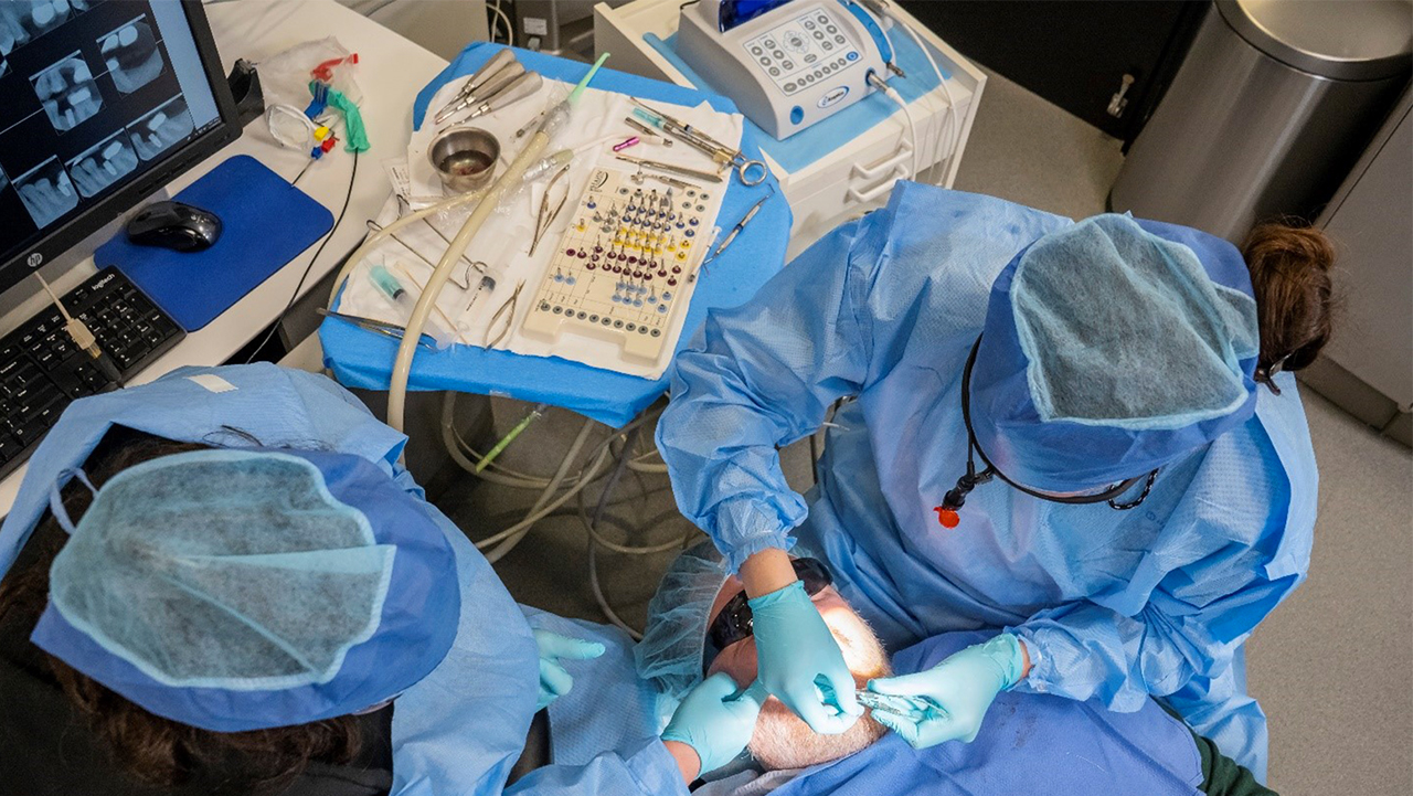 dentists using surgical instrument kits during implant surgery