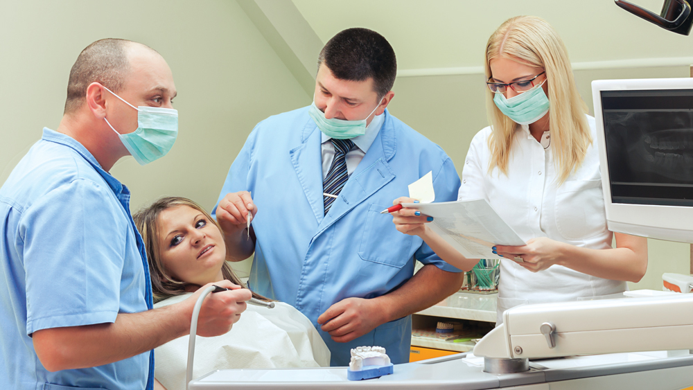 Dentists discussing procedure with patient