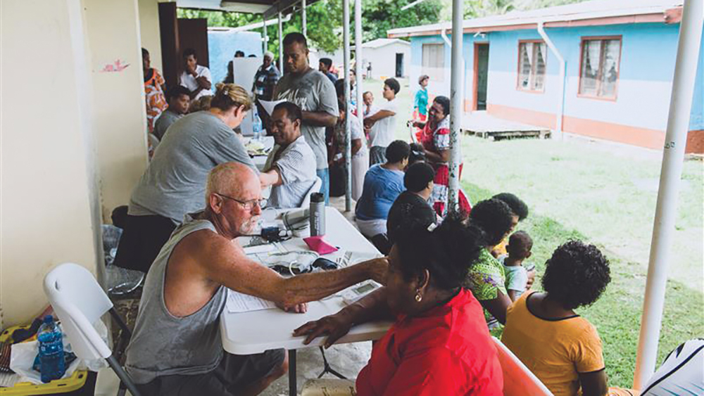 Volunteers conduct medical tests on patients entering the clinic.