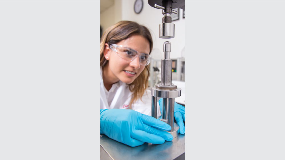 female r&d scientist measures and records force and stress time of debonding