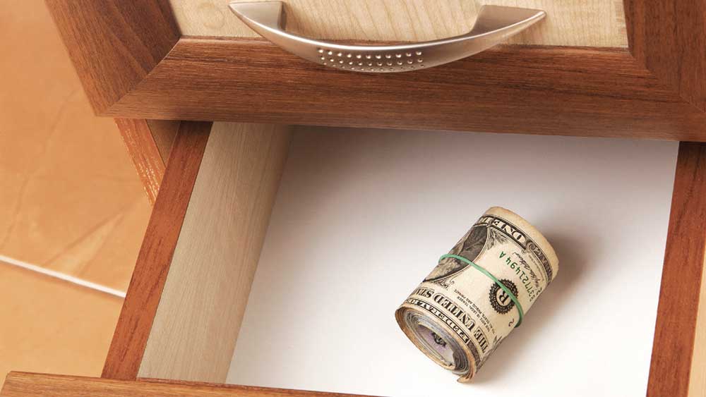 Roll of dollar one bills inside a drawer