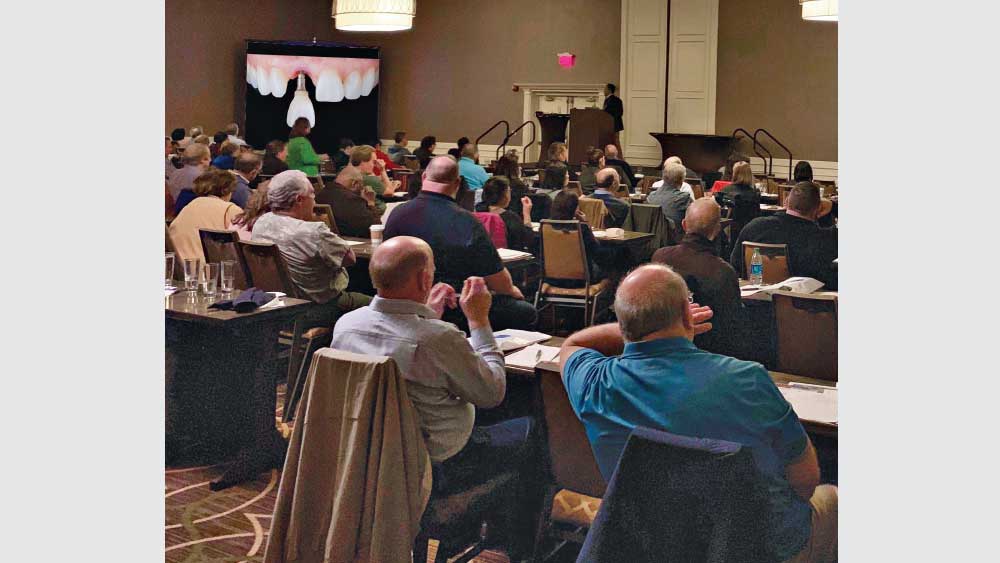 Dr. Paresh Patel speaking to a group of dentists at a live CE event