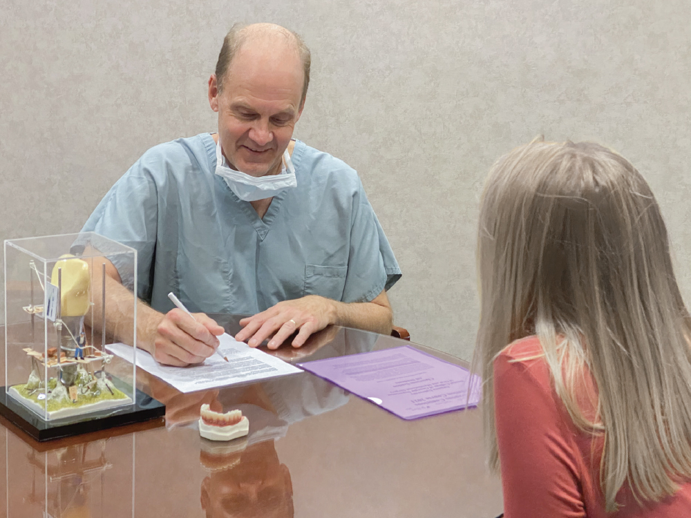 Dr. Resnik filling out medical forms with patient