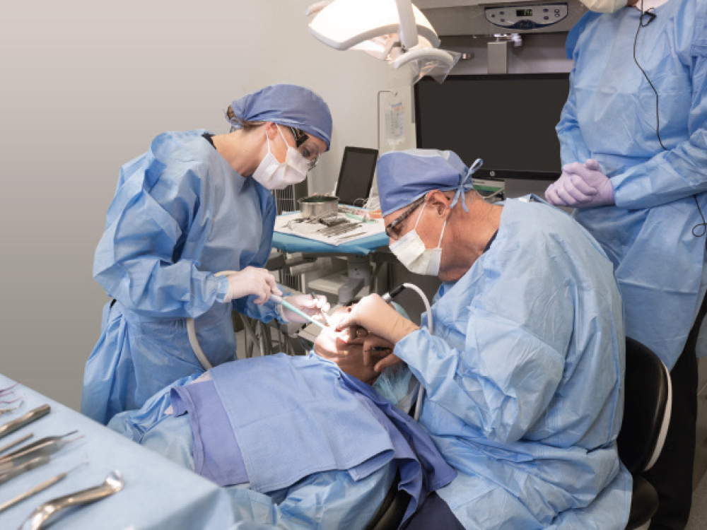 Attendees work on a patient during a hands-on course