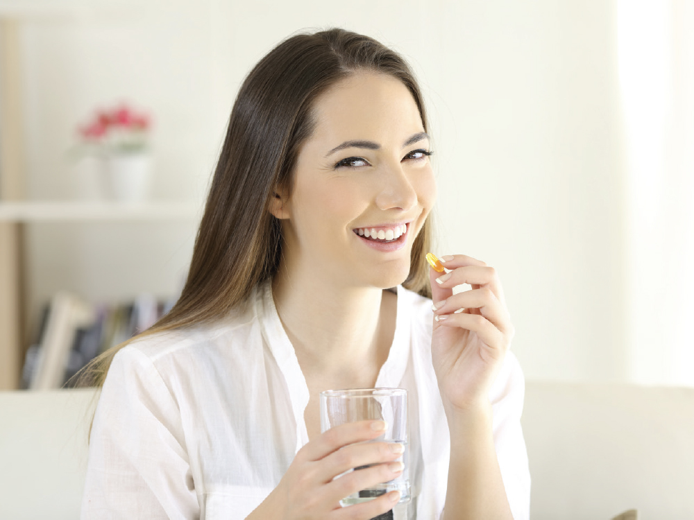 Woman taking a Vitamin D supplement