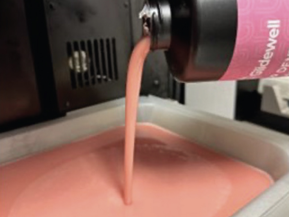 Pink liquid pouring from labeled bottle