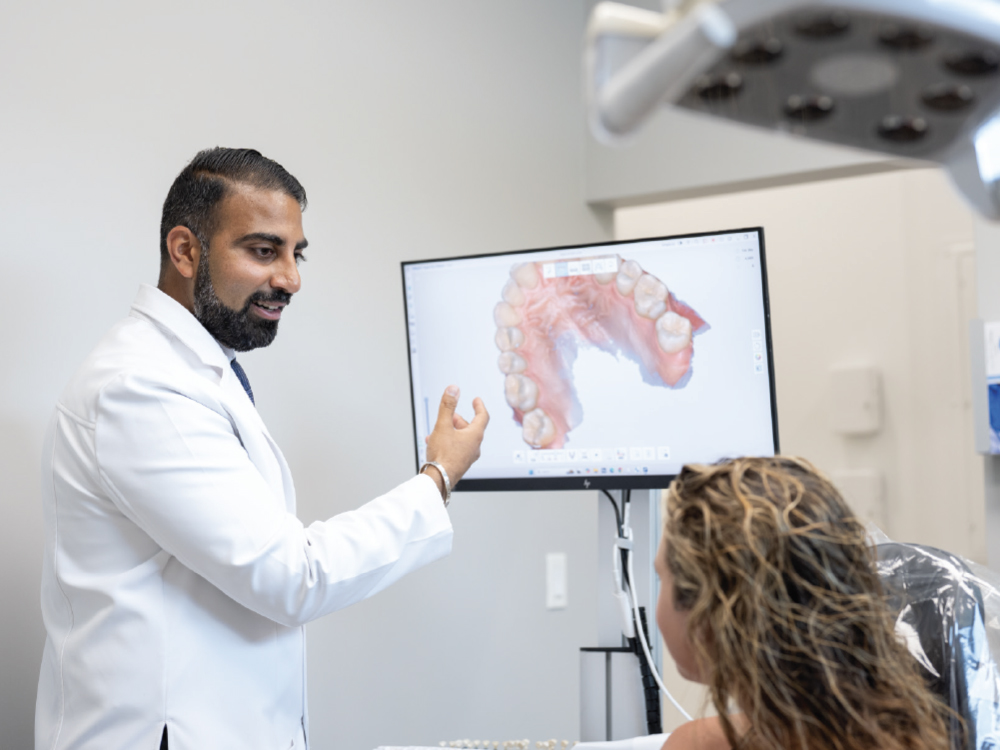 Dr. Darshan Patel reviewing the digital design of a restoration with his patient.