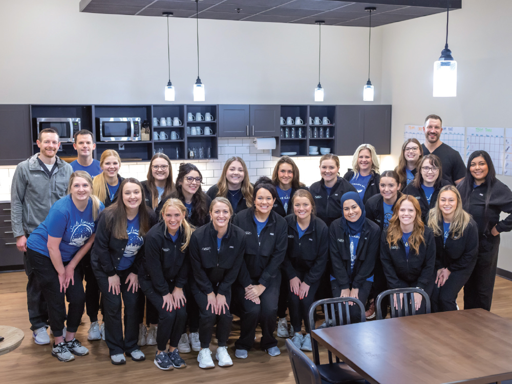 Group portrait of the Capital Dental team posing in their office break room.
